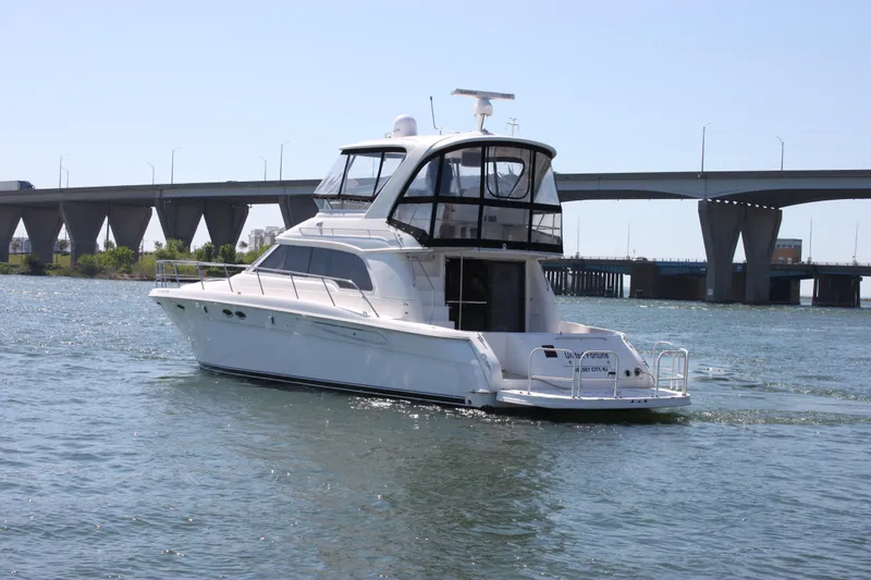 Slide: The Image of 2001 Sea Ray 480 Sedan Bridge yacht cruising near a bridge on a sunny day. - 9