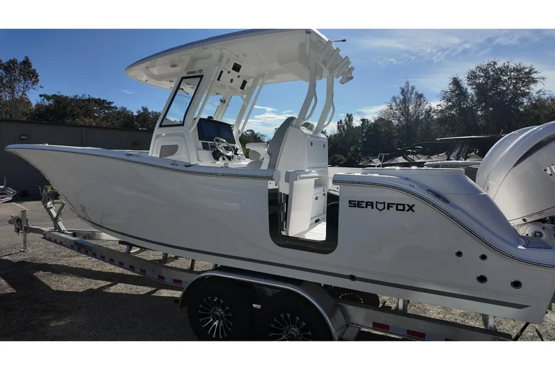 Slide: The Image of 2026 Sea Fox 288 Commander boat on trailer, side view, outdoors. - 2