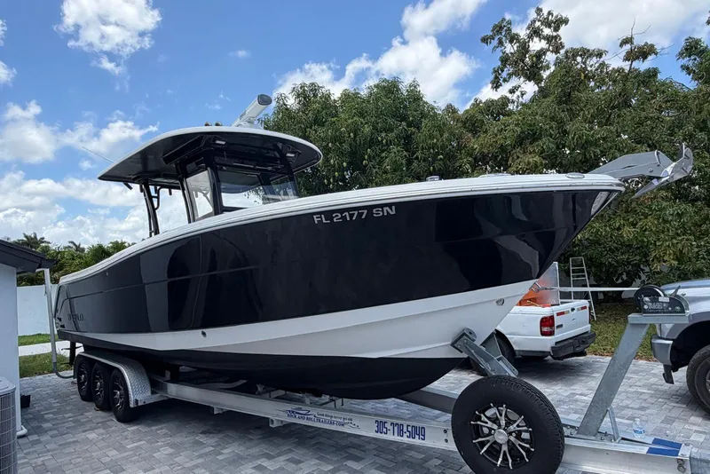 The Image of 2017 Robalo R302 Center Console boat on trailer, parked outdoors. - 0