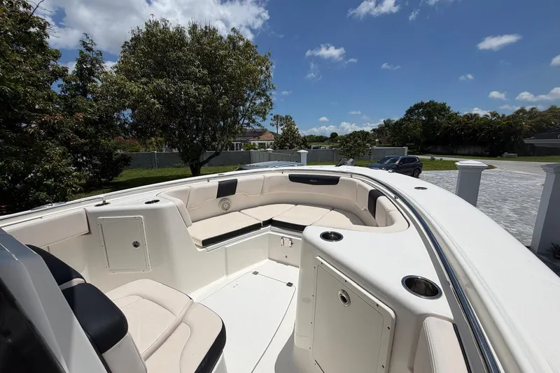 Slide: The Image of 2017 Robalo R302 Center Console boat with spacious seating under a clear blue sky. - 13