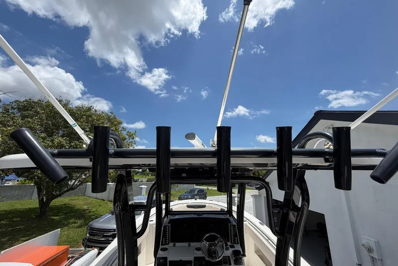 Slide: The Image of 2017 Robalo R302 Center Console boat with rod holders under a clear blue sky. - 16