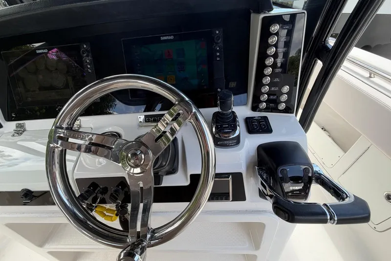 Slide: The Image of 2017 Robalo R302 Center Console helm with steering wheel and control panel. - 20