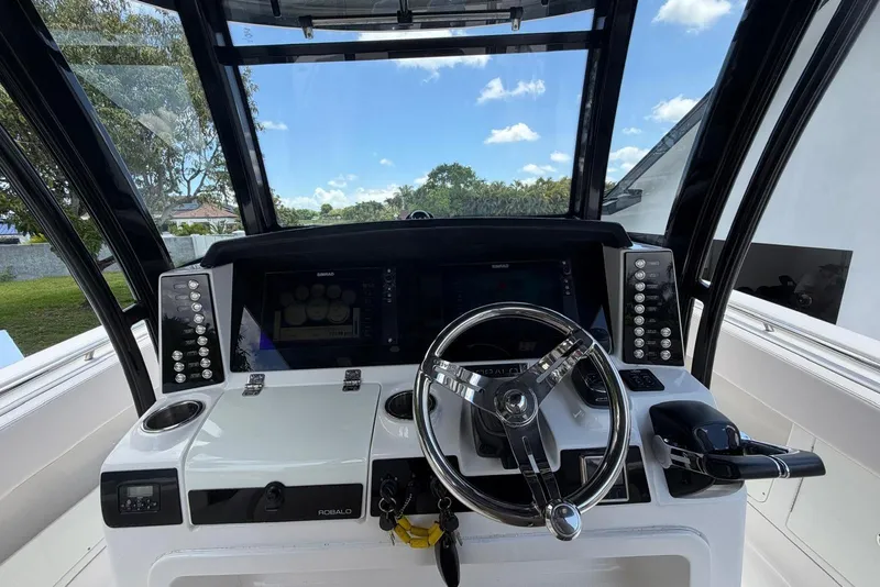 Slide: The Image of 2017 Robalo R302 Center Console helm with steering wheel and navigation controls. - 21