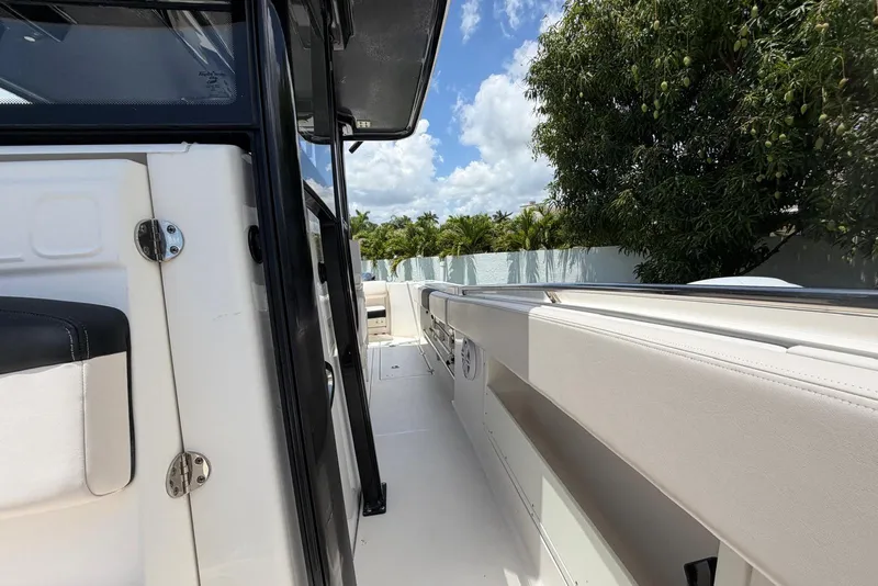 Slide: The Image of 2017 Robalo R302 Center Console boat interior with seating, under a sunny sky. - 26