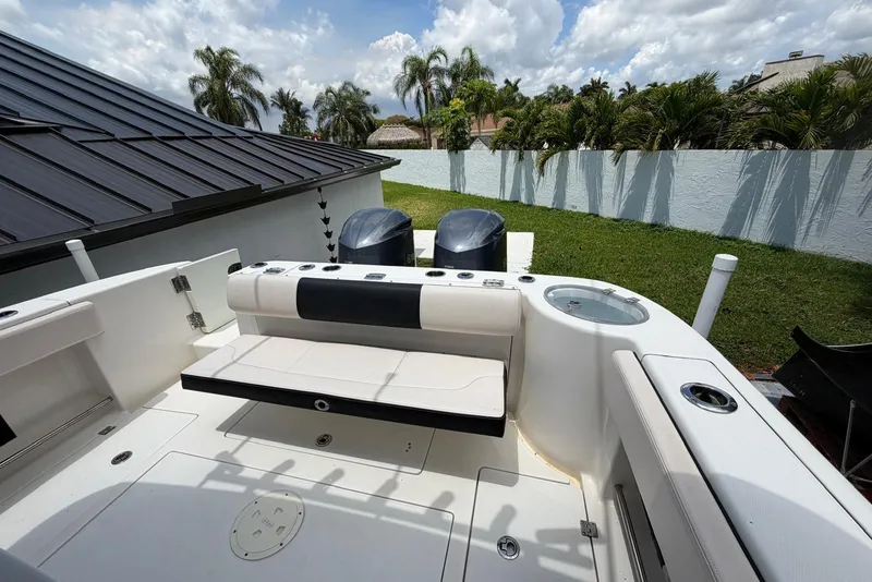 Slide: The Image of 2017 Robalo R302 Center Console boat with dual engines, docked near a garden. - 29