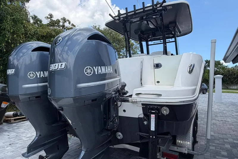 Slide: The Image of 2017 Robalo R302 Center Console with twin Yamaha 300 engines, parked on a driveway. - 32