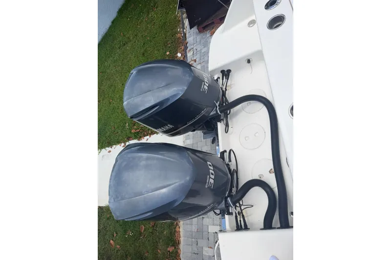 Slide: The Image of 2017 Robalo R302 Center Console with twin Yamaha 300 engines, docked on a paved surface. - 33