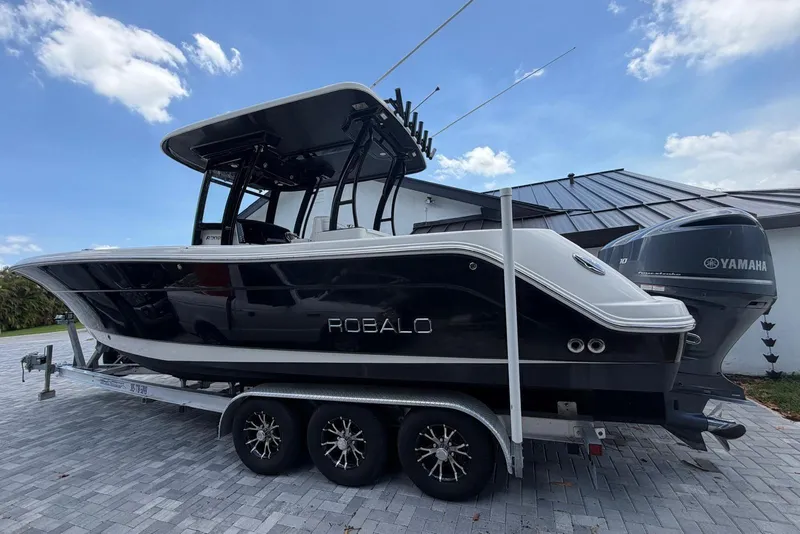 Slide: The Image of 2017 Robalo R302 Center Console boat on trailer, parked outdoors. - 5