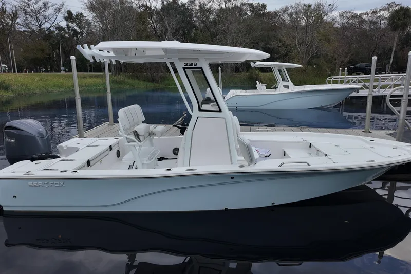 Slide: The Image of 2026 Sea Fox 231 Bay Fox boat docked on calm water, showcasing sleek design. - 3