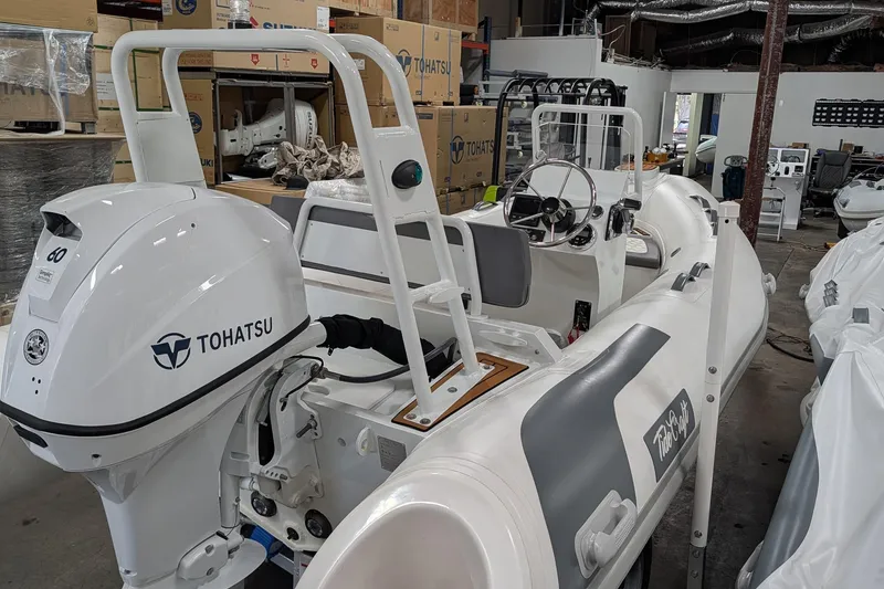 Slide: The Image of 2025 Tide Craft Catalina 13 boat with Tohatsu engine in a workshop setting. - 8