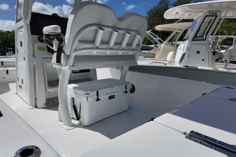 Slide: The Image of 2026 Sea Fox 251 Bay Fox boat interior with seating and cooler under sunny skies. - 13