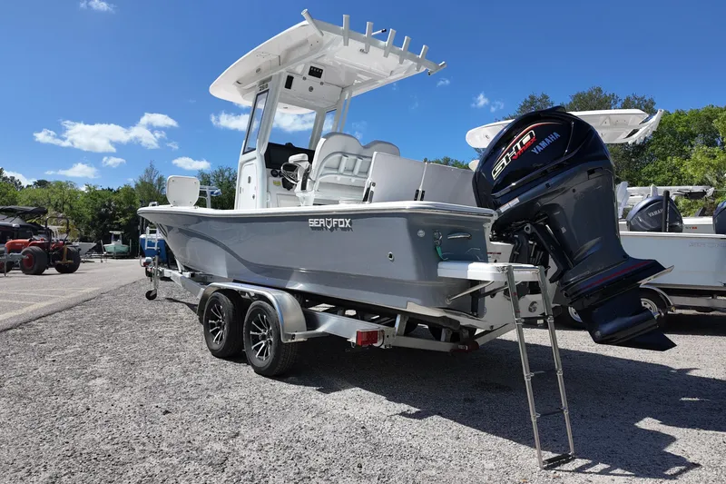 Slide: The Image of 2026 Sea Fox 251 Bay Fox boat on trailer with Yamaha engine, parked outdoors. - 2