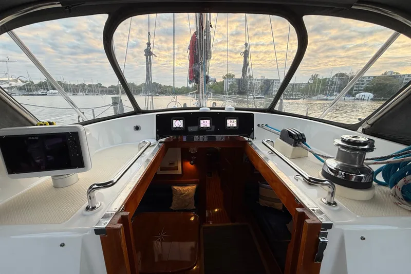 Slide: The Image of Cockpit view of 2014 Hylas 56 sailboat with navigation equipment and marina backdrop. - 14