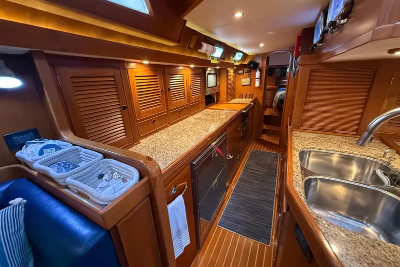 Slide: The Image of Luxurious 2014 Hylas 56 yacht interior with wooden cabinetry and granite countertops. - 20