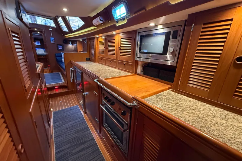 Slide: The Image of Luxurious 2014 Hylas 56 yacht interior with modern kitchen and wooden cabinetry. - 21