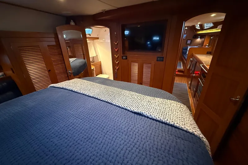 Slide: The Image of Luxurious interior of a 2014 Hylas 56 yacht featuring a cozy bedroom and modern kitchen. - 25