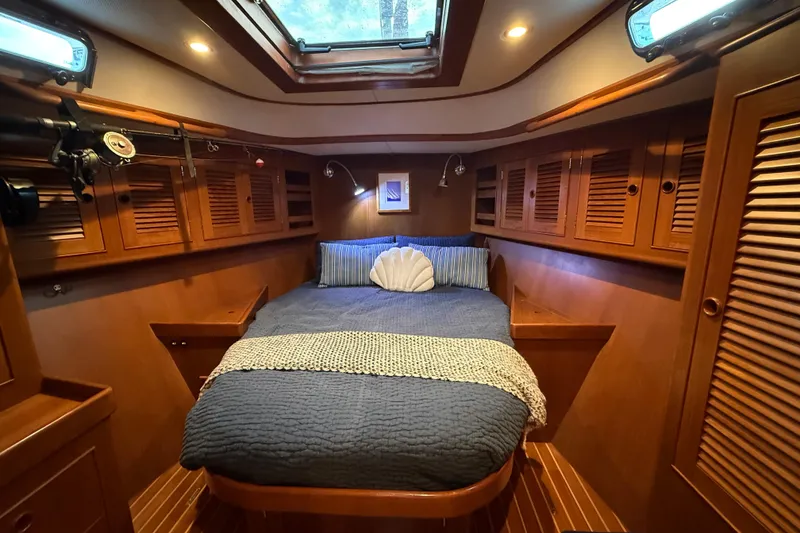 Slide: The Image of Luxurious cabin interior of a 2014 Hylas 56 yacht with cozy bedding and wooden cabinetry. - 28