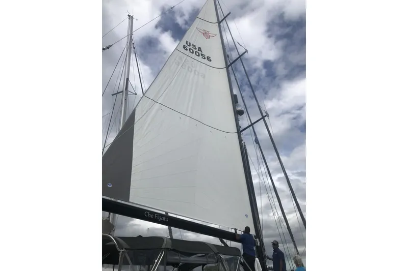 Slide: The Image of Sailing yacht Hylas 56, 2014 model, with crew adjusting sails under cloudy sky. - 32