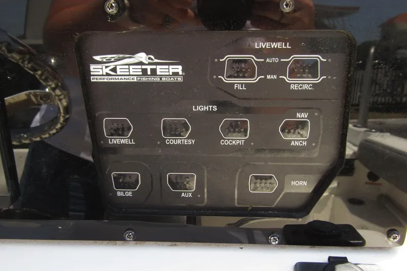 Slide: The Image of Control panel of 2022 Skeeter SX2550 Fish boat with various switches and labels. - 23