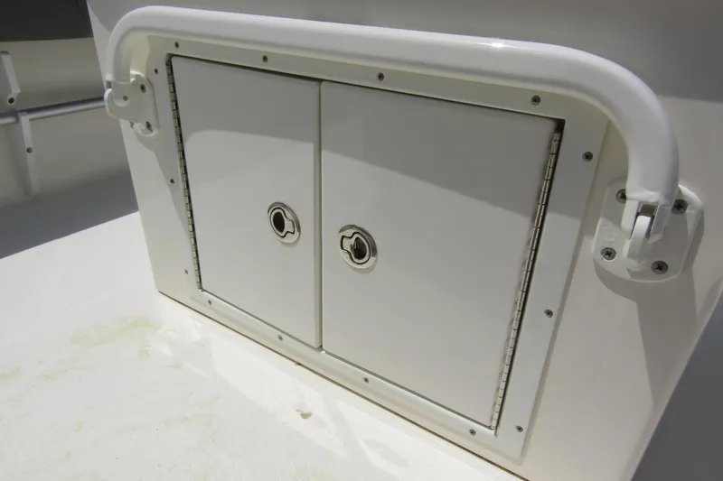 Slide: The Image of Storage compartment on a 2022 Skeeter SX2550 Fish boat, featuring dual doors and secure handles. - 26
