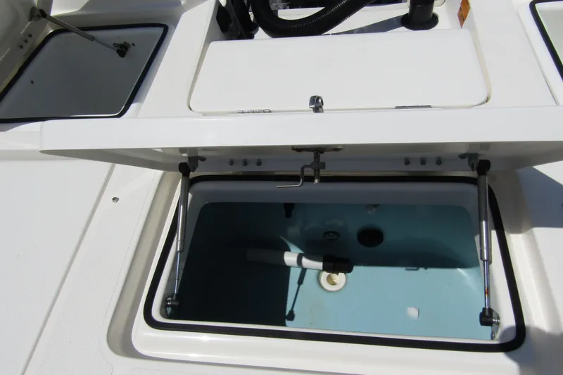 Slide: The Image of 2022 Skeeter SX2550 Fish boat livewell compartment with open lid, showcasing interior features. - 30