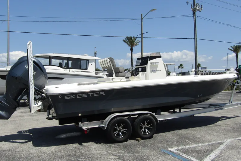 Slide: The Image of 2022 Skeeter SX2550 Fish boat on trailer, parked outdoors under clear sky. - 9