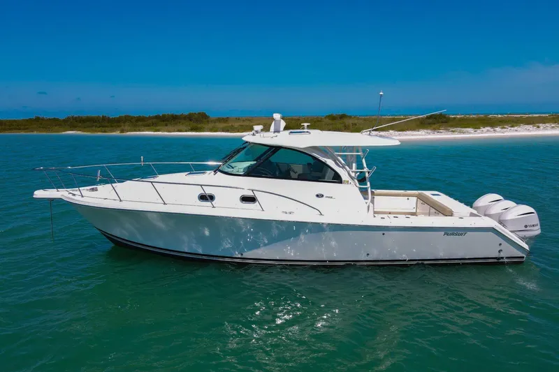 The Image of 2019 Pursuit OS 385 Offshore boat on turquoise water near sandy shore. - 1