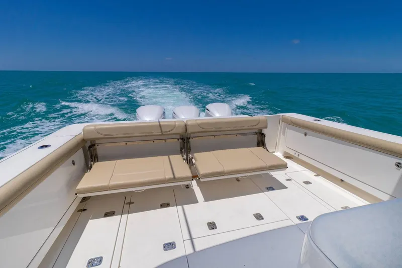 Slide: The Image of 2019 Pursuit OS 385 Offshore boat cruising on open sea, featuring spacious deck seating. - 10