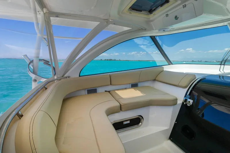 Slide: The Image of 2019 Pursuit OS 385 Offshore boat interior with beige seating and ocean view. - 14