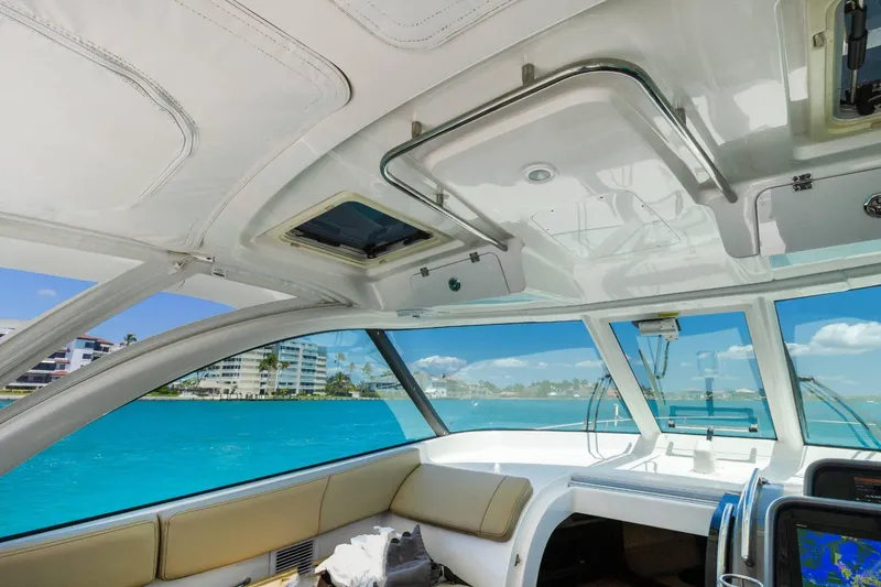 Slide: The Image of Interior view of 2019 Pursuit OS 385 Offshore boat with ocean and buildings in background. - 19