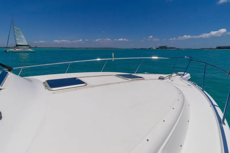 Slide: The Image of 2019 Pursuit OS 385 Offshore yacht on turquoise waters, with a sailboat in the background. - 20