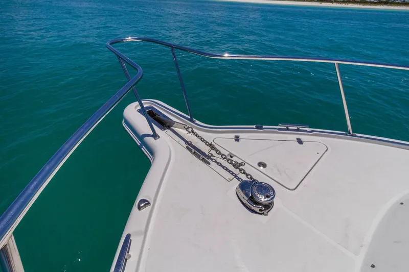 Slide: The Image of Bow of 2019 Pursuit OS 385 Offshore boat with anchor chain, on clear blue water. - 22