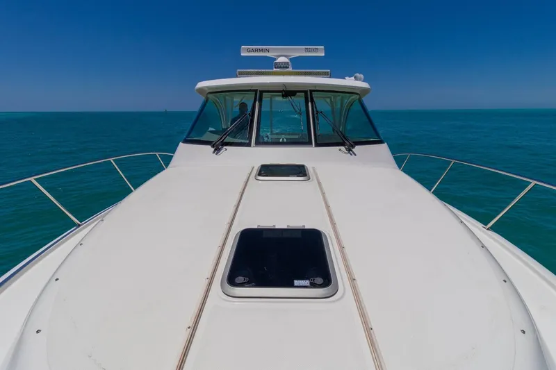 Slide: The Image of 2019 Pursuit OS 385 Offshore boat on open sea under clear blue sky. - 23