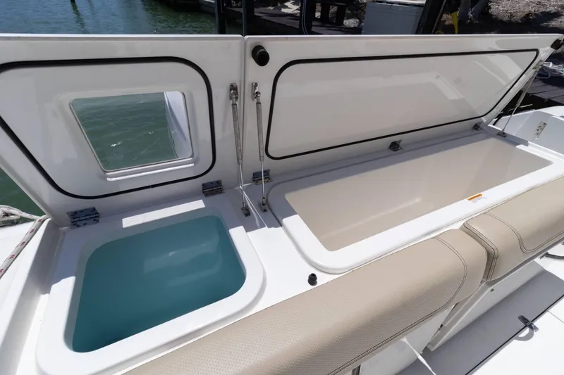 Slide: The Image of 2019 Pursuit OS 385 Offshore boat storage compartments open, showcasing interior space. - 27