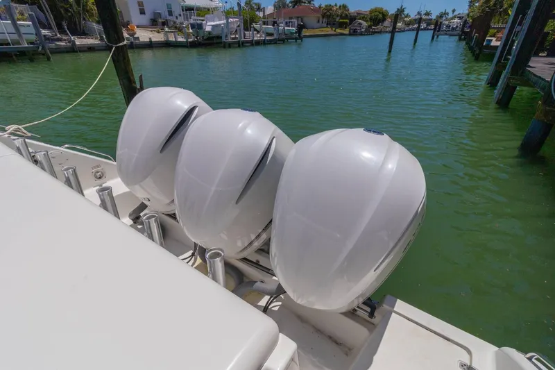 Slide: The Image of 2019 Pursuit OS 385 Offshore boat with triple outboard engines docked in a marina. - 29