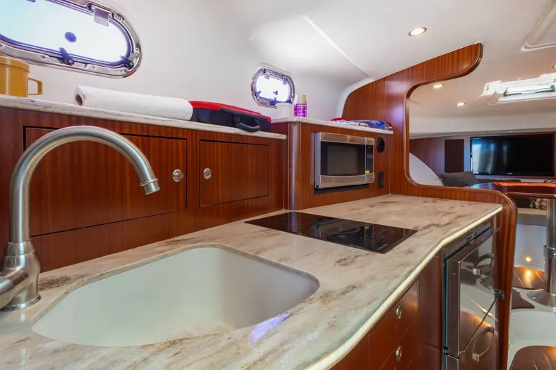 Slide: The Image of Luxurious 2019 Pursuit OS 385 Offshore yacht kitchen with modern amenities and elegant wood finish. - 32