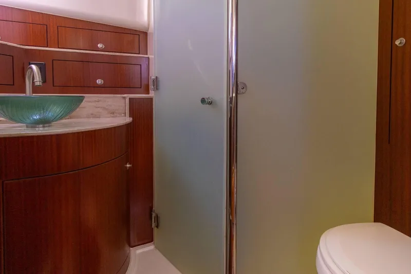 Slide: The Image of 2019 Pursuit OS 385 Offshore bathroom with glass sink and wooden cabinetry. - 35