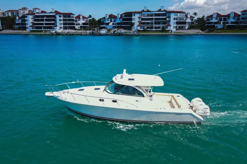 Slide: The Image of 2019 Pursuit OS 385 Offshore boat cruising on turquoise water near waterfront buildings. - 4