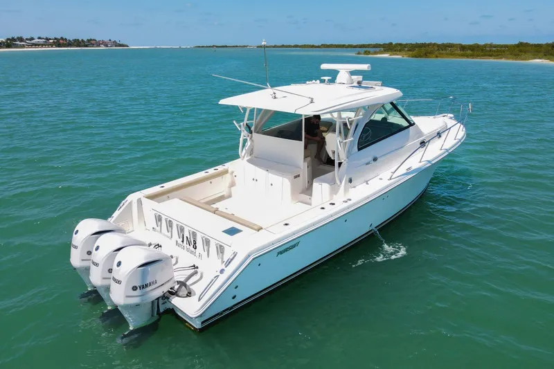 Slide: The Image of 2019 Pursuit OS 385 Offshore boat cruising on clear blue water. - 5