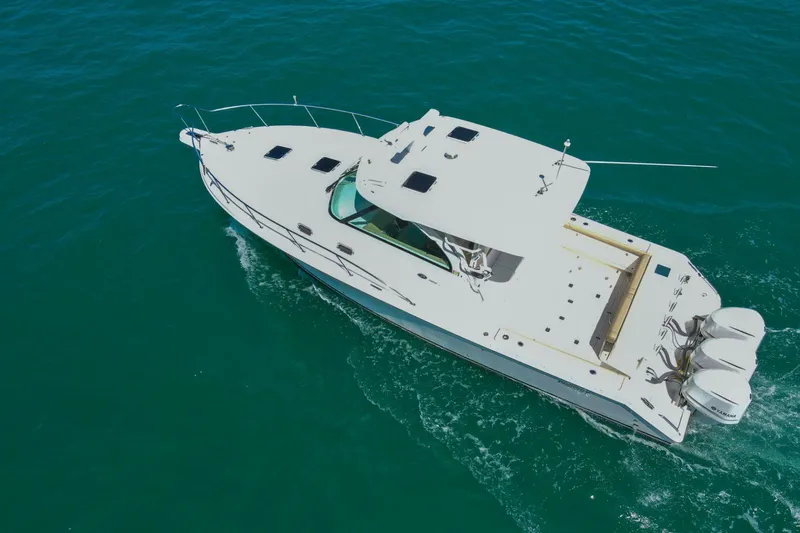 Slide: The Image of Aerial view of 2019 Pursuit OS 385 Offshore boat cruising on clear blue water. - 50