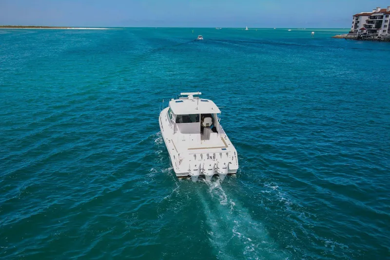Slide: The Image of 2019 Pursuit OS 385 Offshore cruising in clear blue ocean waters. - 54