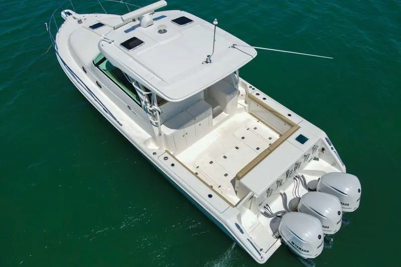Slide: The Image of 2019 Pursuit OS 385 Offshore boat with triple Yamaha engines on clear water. - 6