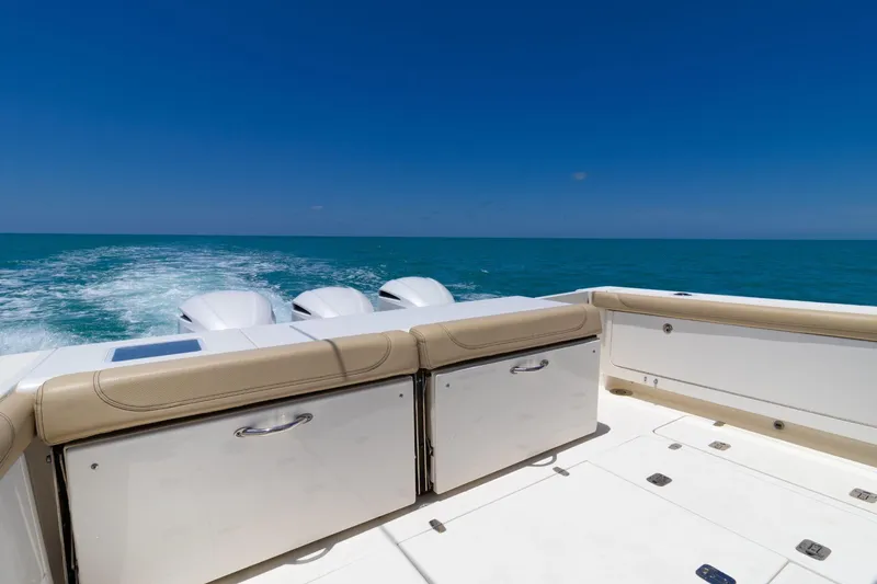 Slide: The Image of 2019 Pursuit OS 385 Offshore boat cruising on open sea under clear blue sky. - 9