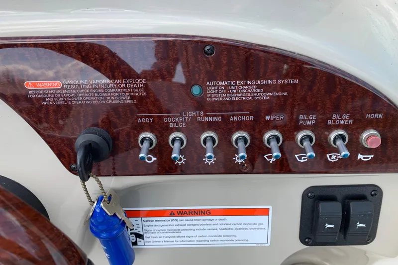 Slide: The Image of Control panel of a 2012 Sea Ray 240 Sundancer boat with labeled switches and warnings. - 10