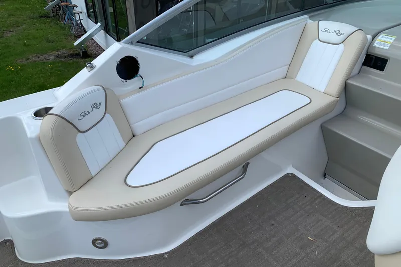Slide: The Image of 2012 Sea Ray 240 Sundancer boat interior with beige and white seating. - 11