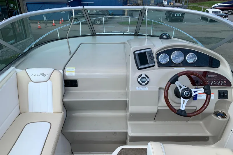 Slide: The Image of 2012 Sea Ray 240 Sundancer boat dashboard with steering wheel and gauges. - 14