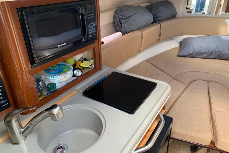 Slide: The Image of Interior of 2012 Sea Ray 240 Sundancer with kitchenette and cozy seating area. - 17