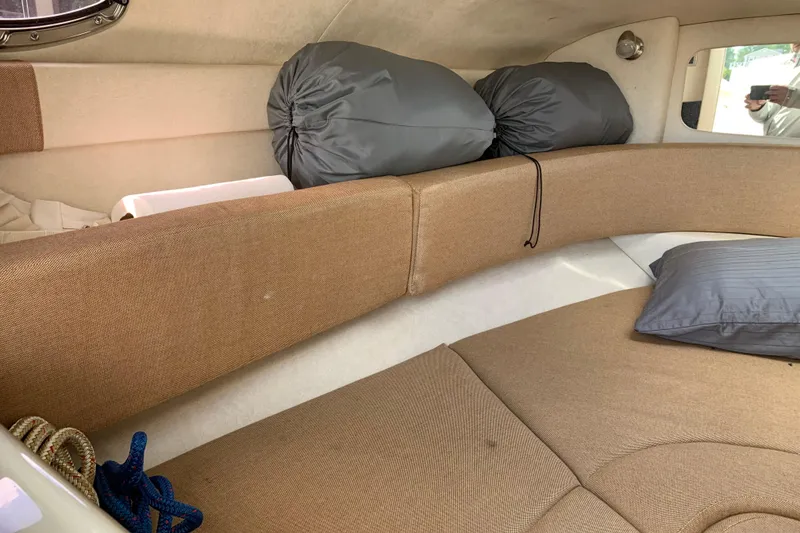 Slide: The Image of Interior cabin of a 2012 Sea Ray 240 Sundancer with cushions and storage bags. - 18