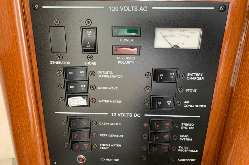 Slide: The Image of Control panel of a 2012 Sea Ray 240 Sundancer boat, featuring AC and DC switches. - 20