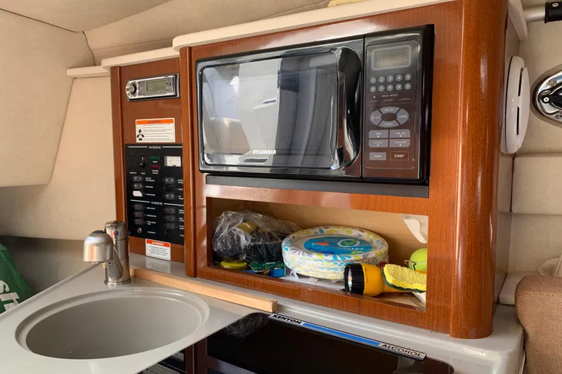 Slide: The Image of Interior of 2012 Sea Ray 240 Sundancer with microwave and sink. - 22